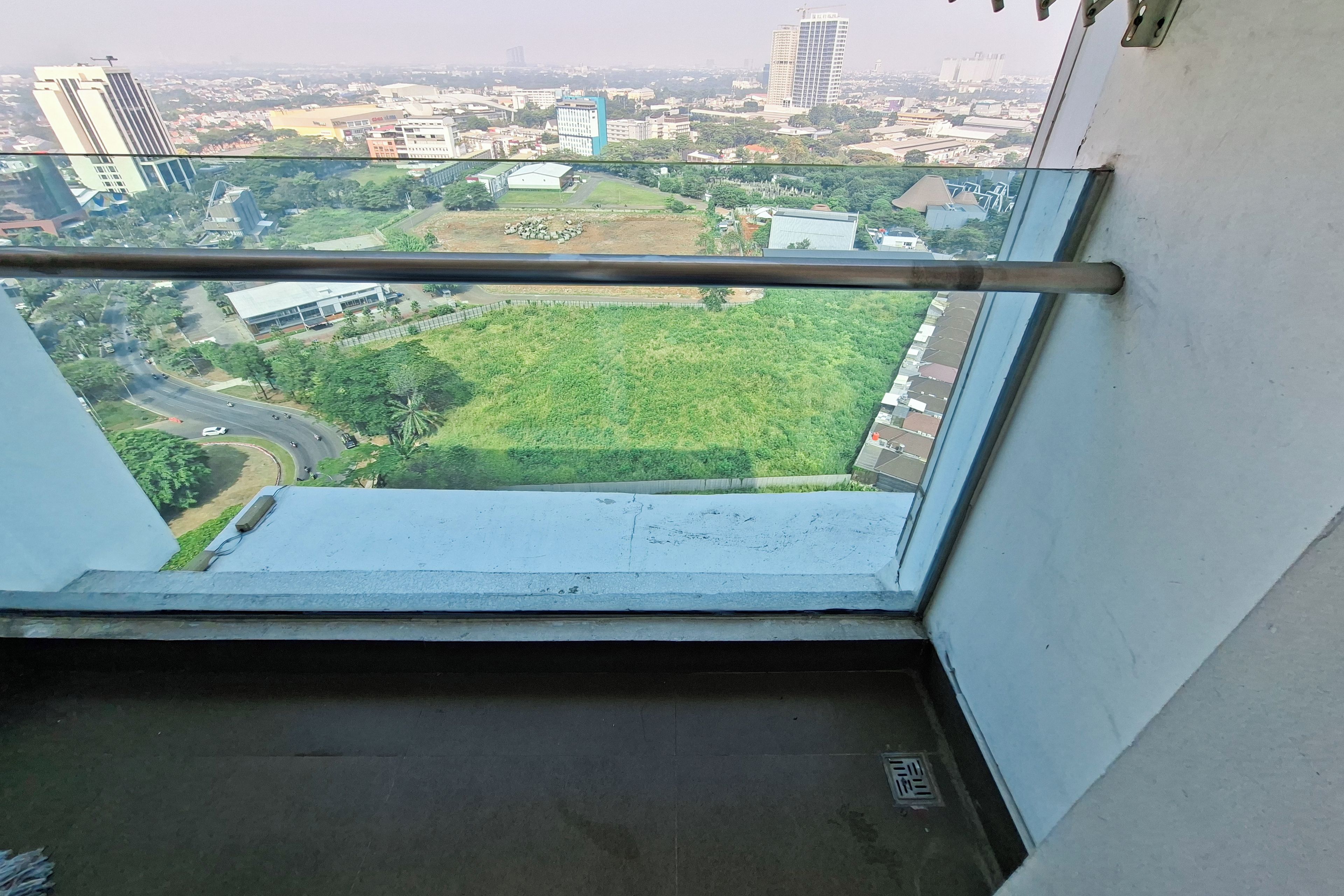 A high-rise building with a view of a cityscape, including roads and greenery.