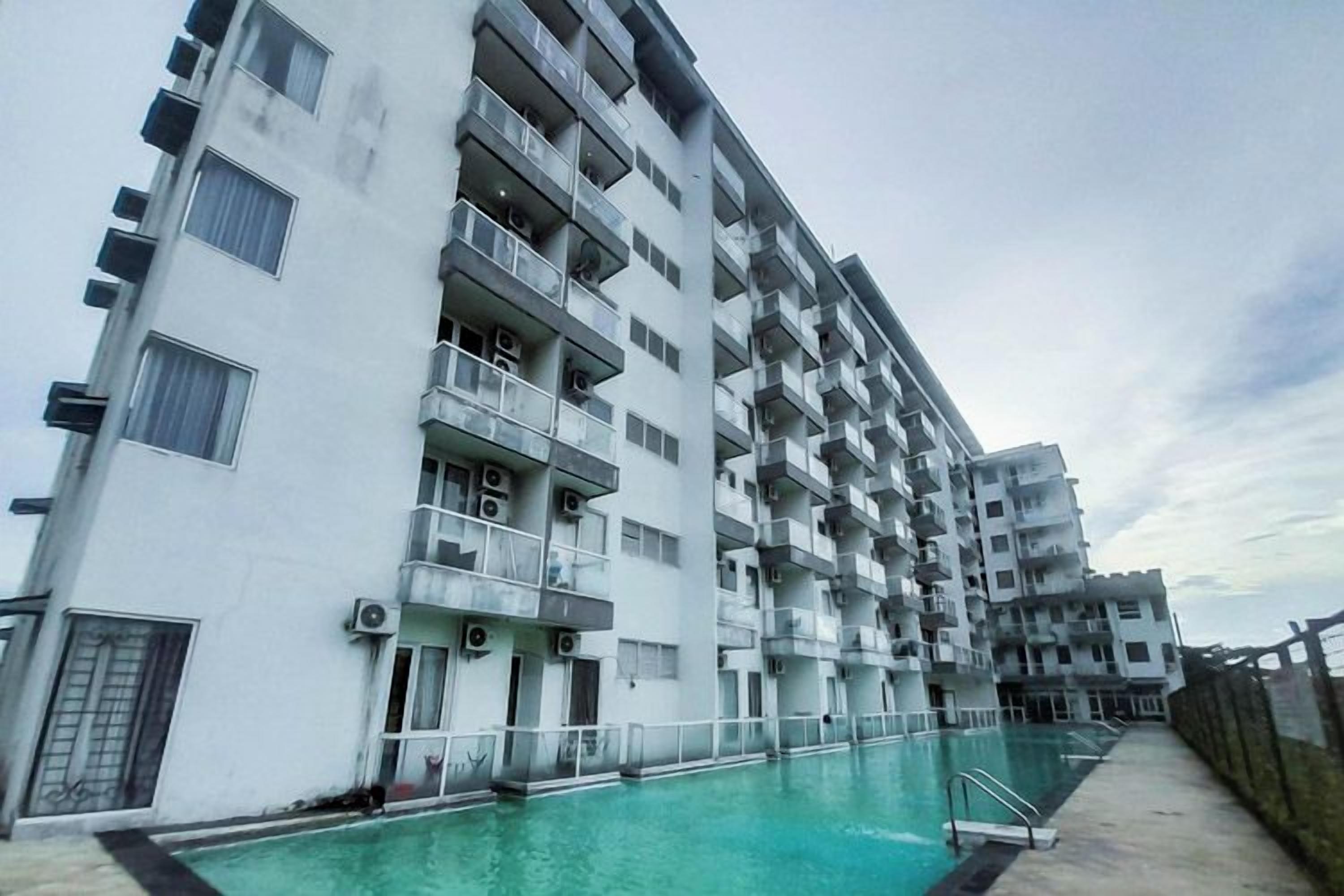A multi-story residential building with balconies and a swimming pool.