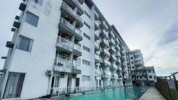A multi-story residential building with balconies and a swimming pool.