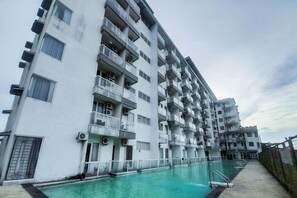 A multi-story residential building with balconies and a swimming pool. - Spacious And Warm 2Br At Apartment Vivo (Depok)