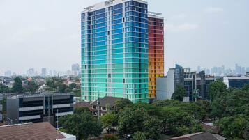 A multi-story building with a grid-like facade, surrounded by trees and other buildings.