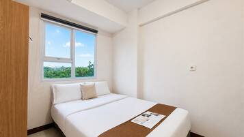 Una habitación de hotel con una cama, un ventanal con vistas y un armario de madera.