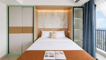 A hotel room with a bed, a magazine on the bed, a wardrobe, and a view through the window.