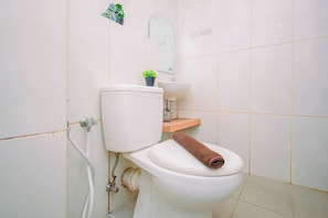Ein Badezimmer mit Toilette, Waschbecken und Spiegel.