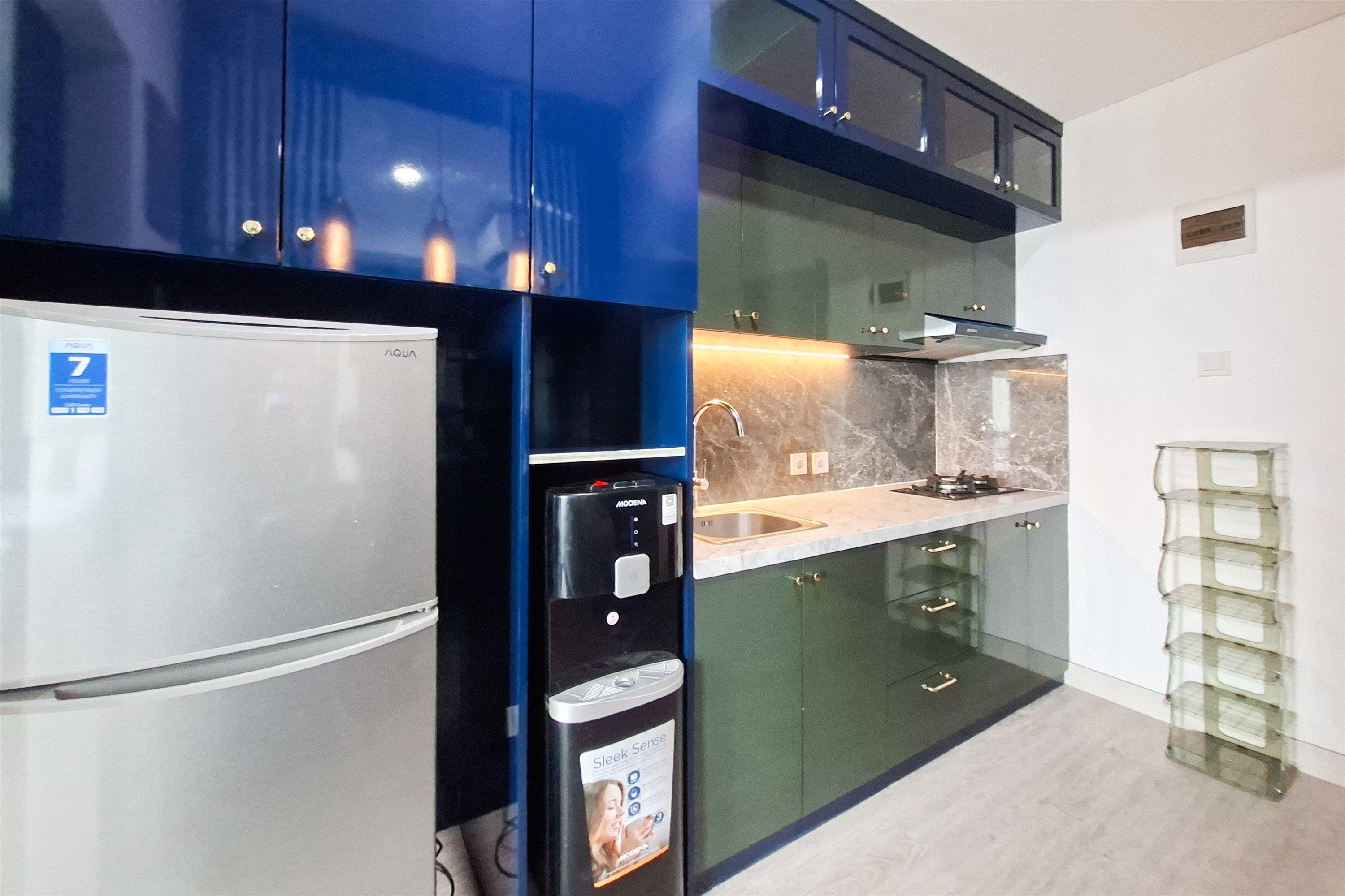 Una cocina moderna con refrigerador de acero inoxidable, dispensador de agua y horno empotrado.