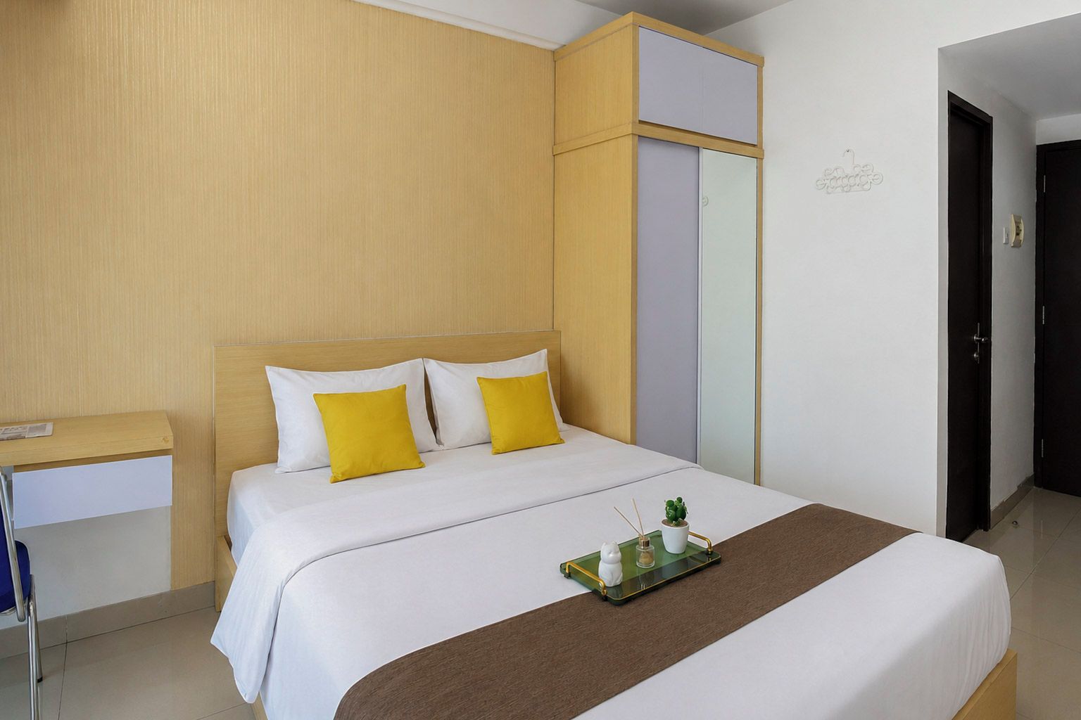 Ein Hotelzimmer mit Bett, Nachttisch und kleinem Schreibtisch.