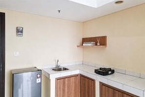 Eine Küche mit einem Edelstahl-Kühlschrank, einer Spüle und einem Holzschrank.