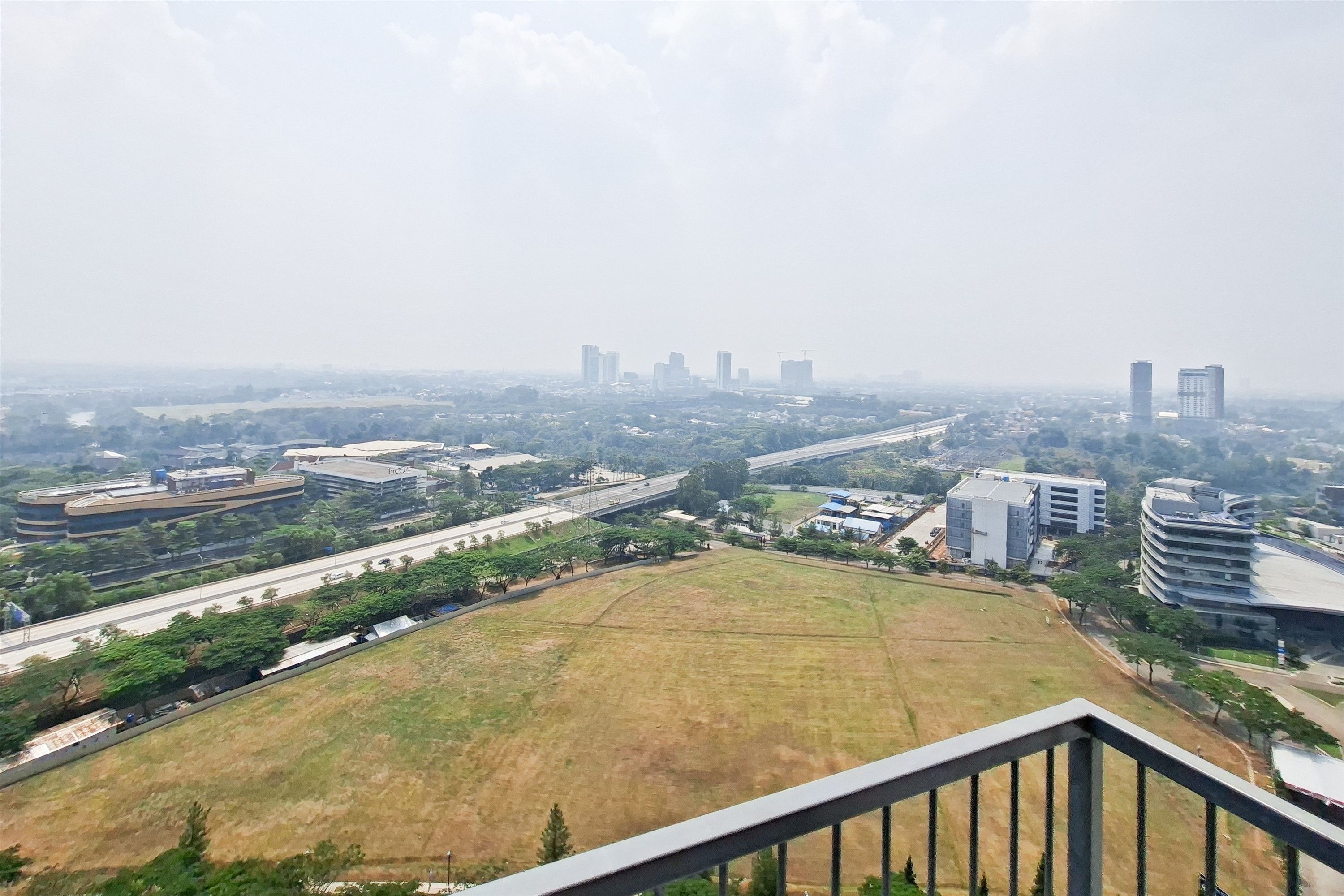 A cityscape with buildings, roads, and a large open field.