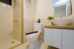 Ein Badezimmer mit Dusche, Toilette, Waschbecken und Spiegel.