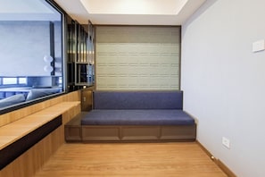 Une pièce moderne avec un banc intégré, une fenêtre équipée de stores et un plancher en bois.