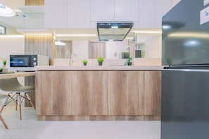 Una cocina moderna con una isla central, electrodomésticos de acero inoxidable y un armario de madera.