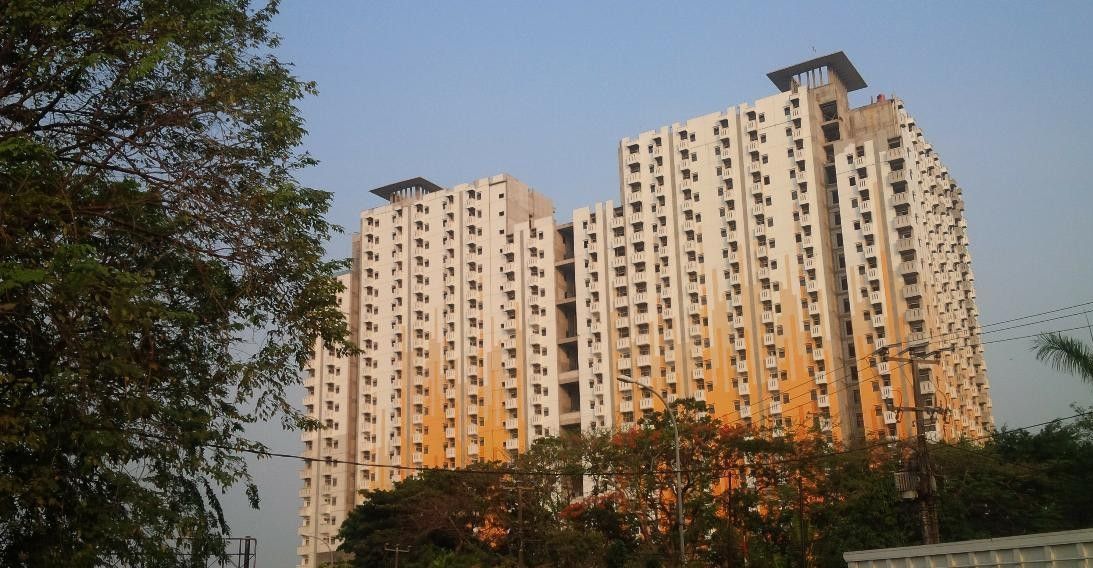 Un edificio residencial alto con varios pisos y balcones.