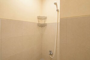 A corner shower with a handheld showerhead and a wall-mounted faucet. - Happy Stay Studio At Apartment Menara Rungkut (Surabaya)