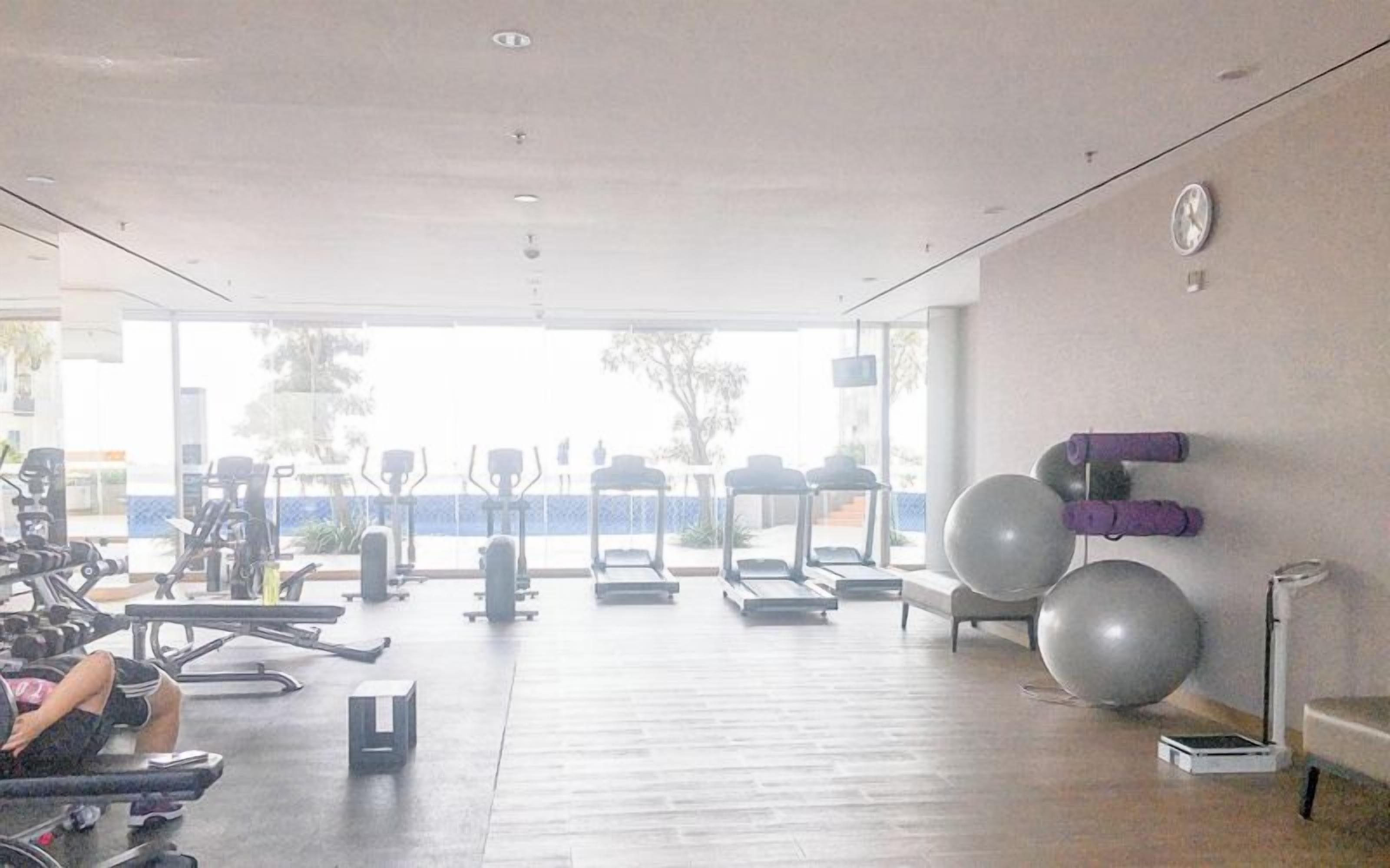 A gym with exercise equipment, treadmills, and large exercise balls.