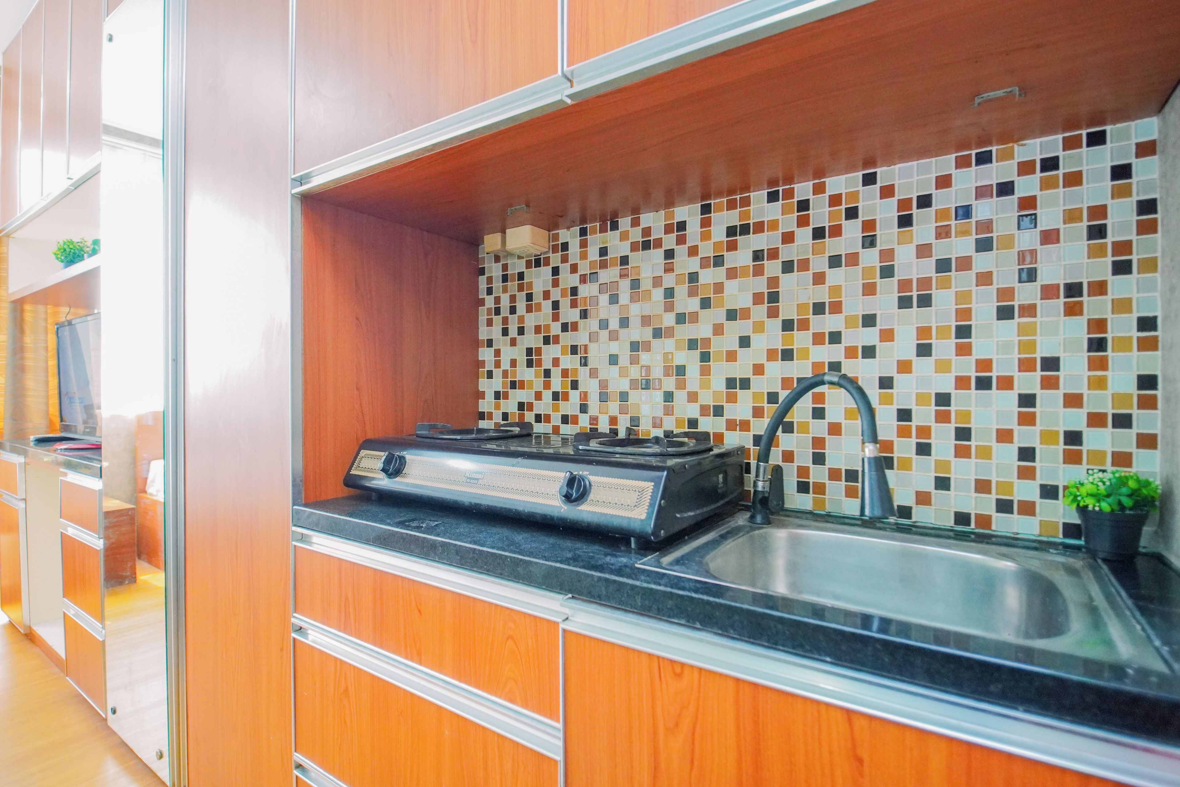 A kitchen with a tiled backsplash, a gas stove, and a sink.