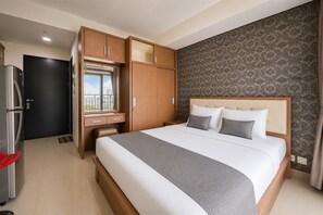 Ein Hotelzimmer mit Bett, Kleiderschrank und einer kleinen Küchenzeile.