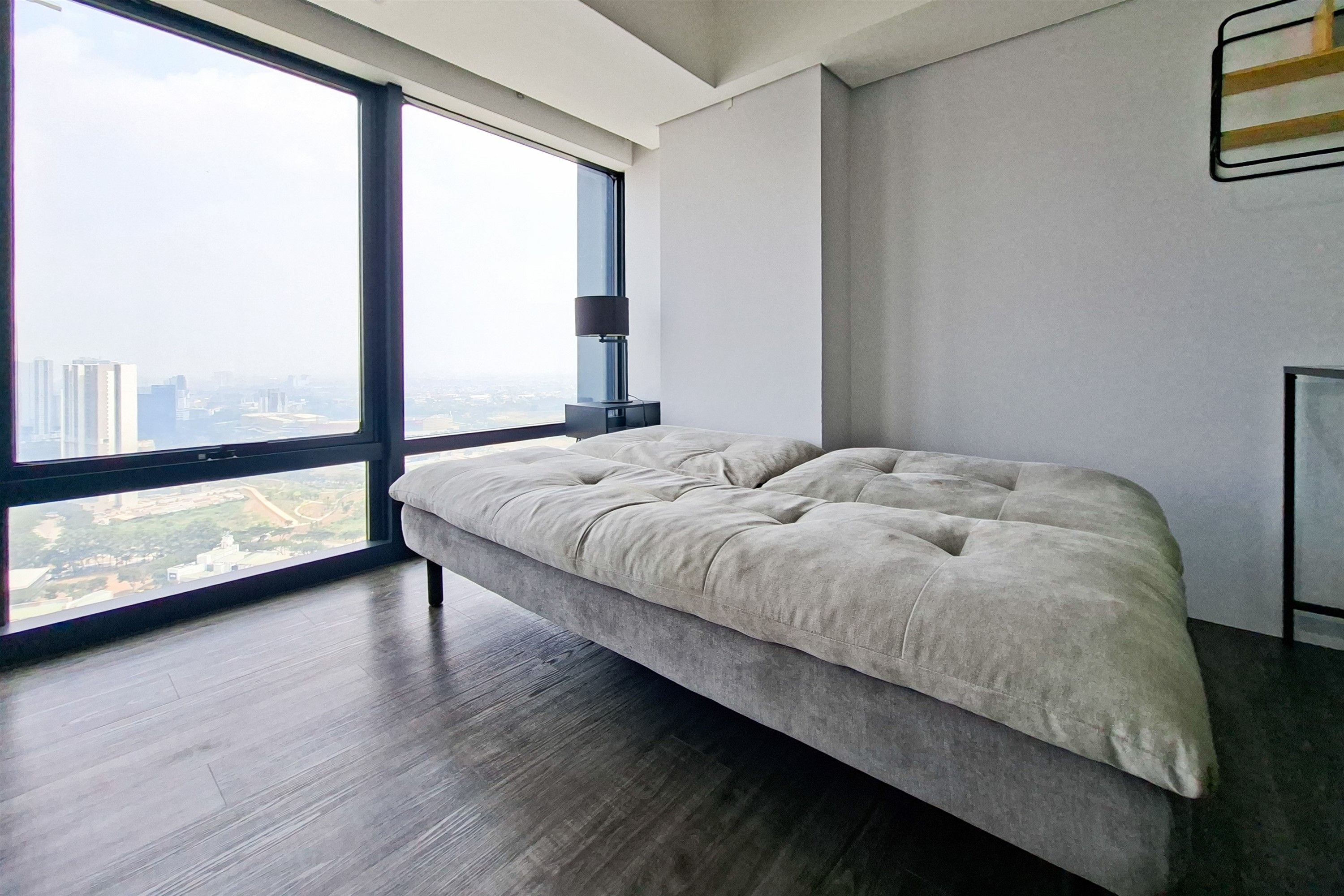 Une chambre à coucher moderne avec une grande fenêtre, un lit et une table de chevet.