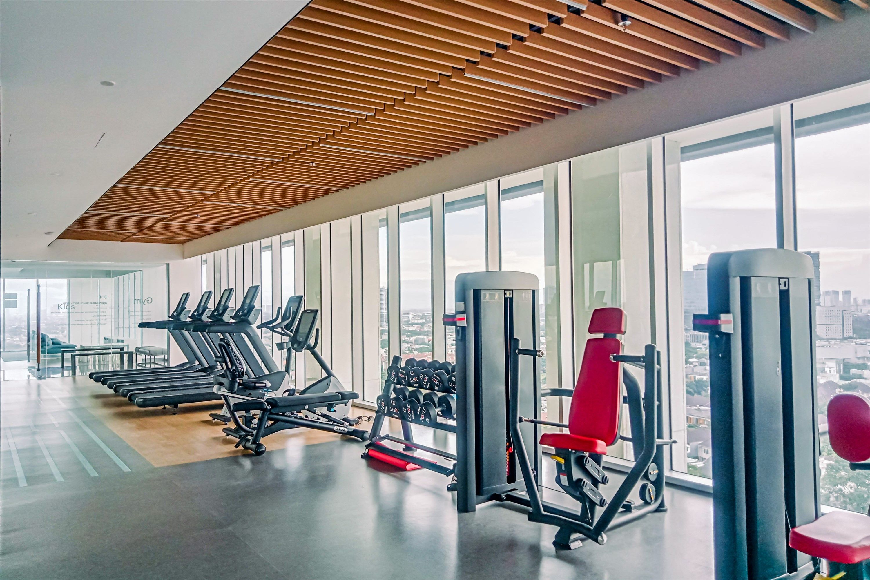 A modern gym with treadmills, dumbbells, and weight machines.
