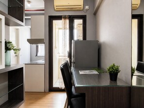 Eine moderne Küche mit einem Einbaukühlschrank, einem Esstisch mit Glasplatte und einem Topf mit Pflanze.