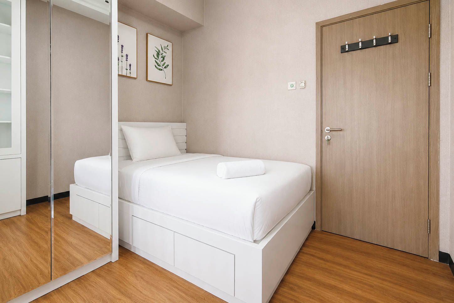 A bedroom with a bed, a wardrobe, a door, and a mirror.