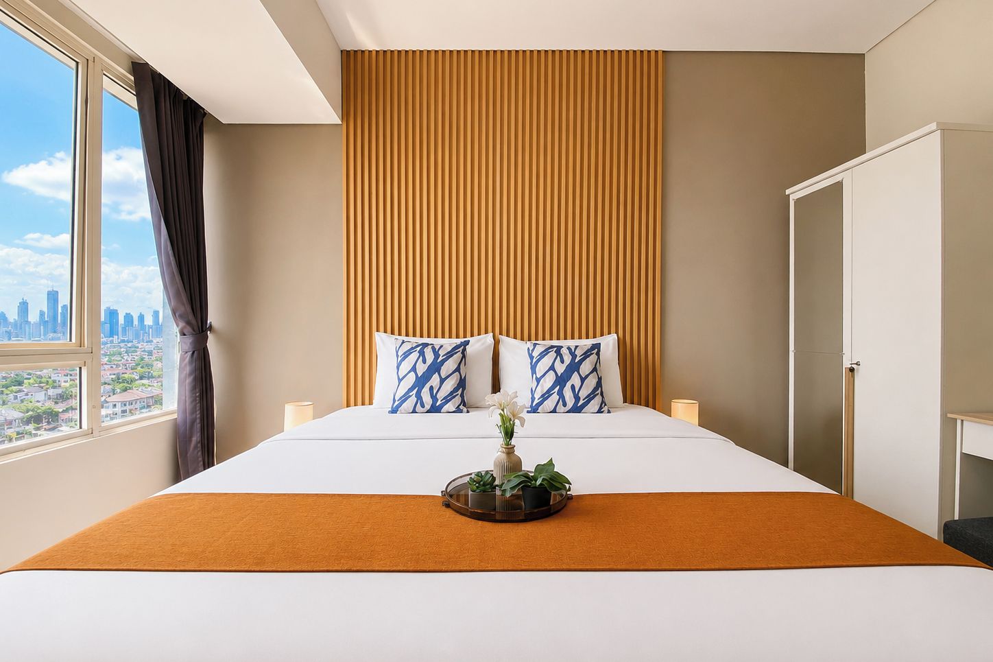 A hotel room with a large bed, a view of the city, and a window with curtains.