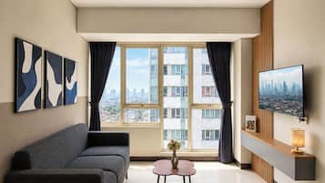 A modern living room with a sofa, a coffee table, a TV, and a city view.
