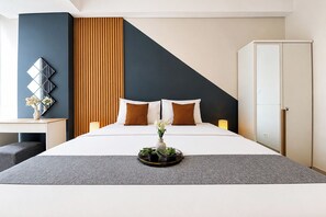 A modern hotel room with a large bed, a desk, and a wardrobe. - Modern Look And Cozy Studio At Apartment Tamansari Iswara (Bekasi)
