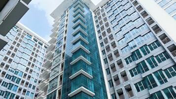 Un edificio moderno de rascacielos con varios pisos, ventanas amplias y balcones.