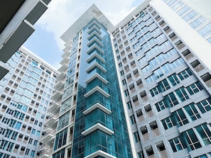 A modern high-rise building with multiple floors, large windows, and balconies. - Modern Look And Cozy Studio At Apartment Tamansari Iswara (Bekasi)