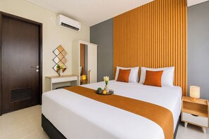 A hotel room with a bed, a desk, a wardrobe, and a nightstand. - Tastefully Designed 3Br At Apartment Nifarro Park (Jakarta)