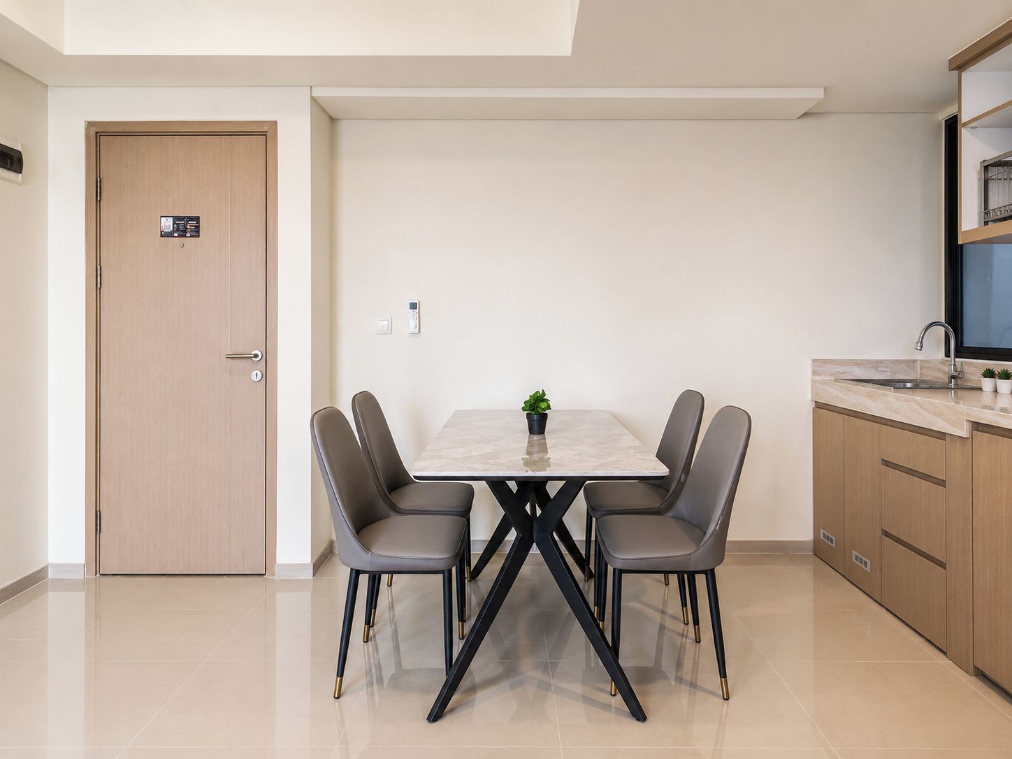 Una cocina moderna con una mesa de comedor, sillas y una pequeña planta en maceta.