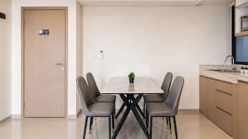 Una cocina moderna con una mesa de comedor, sillas y una pequeña planta en maceta.