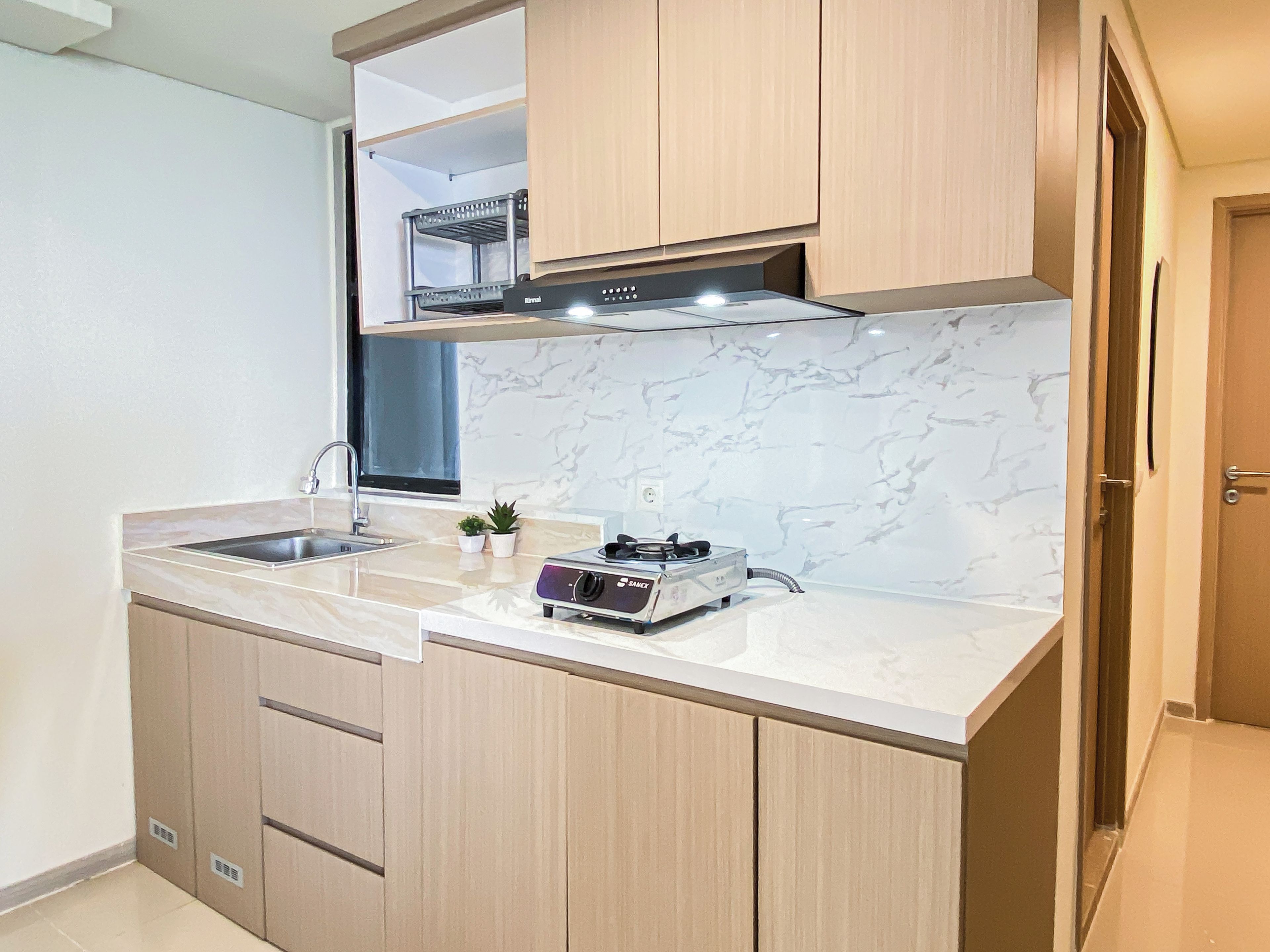 Una cocina compacta con estufa integrada, un lavabo y armarios de madera.