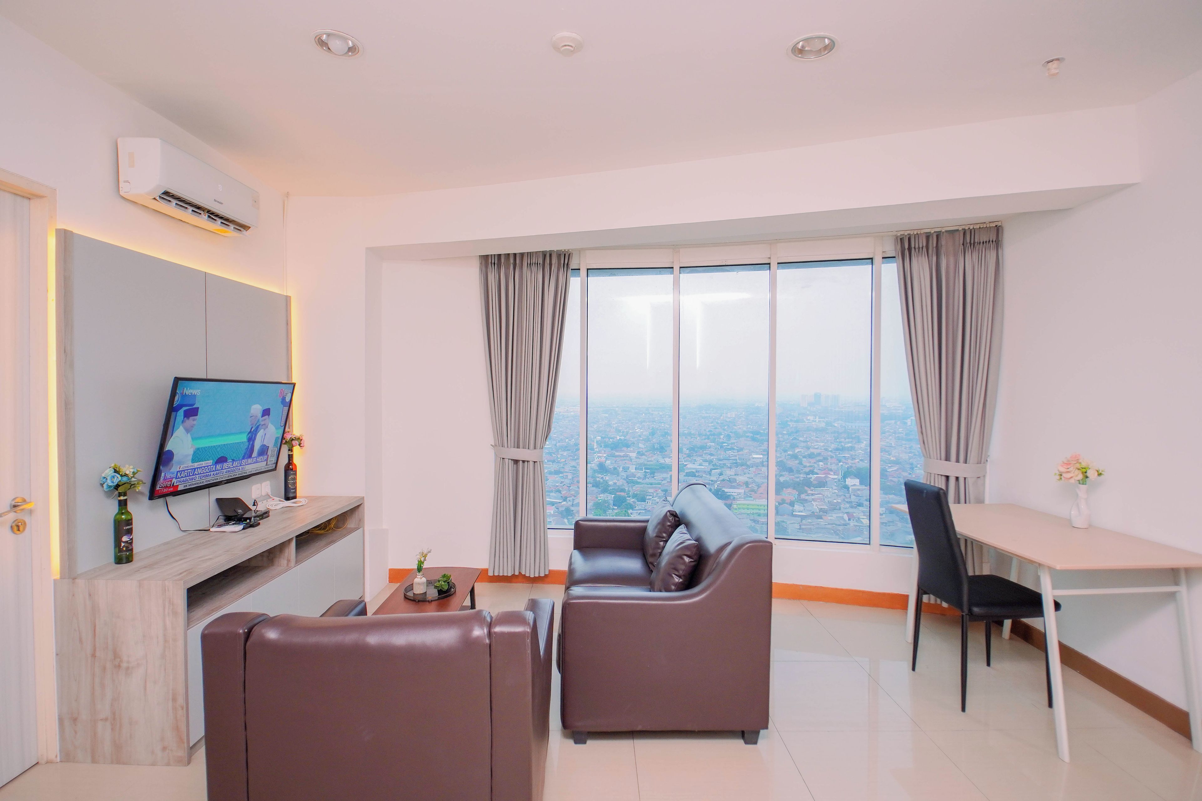 Una sala de estar moderna con televisión, sofá y comedor.