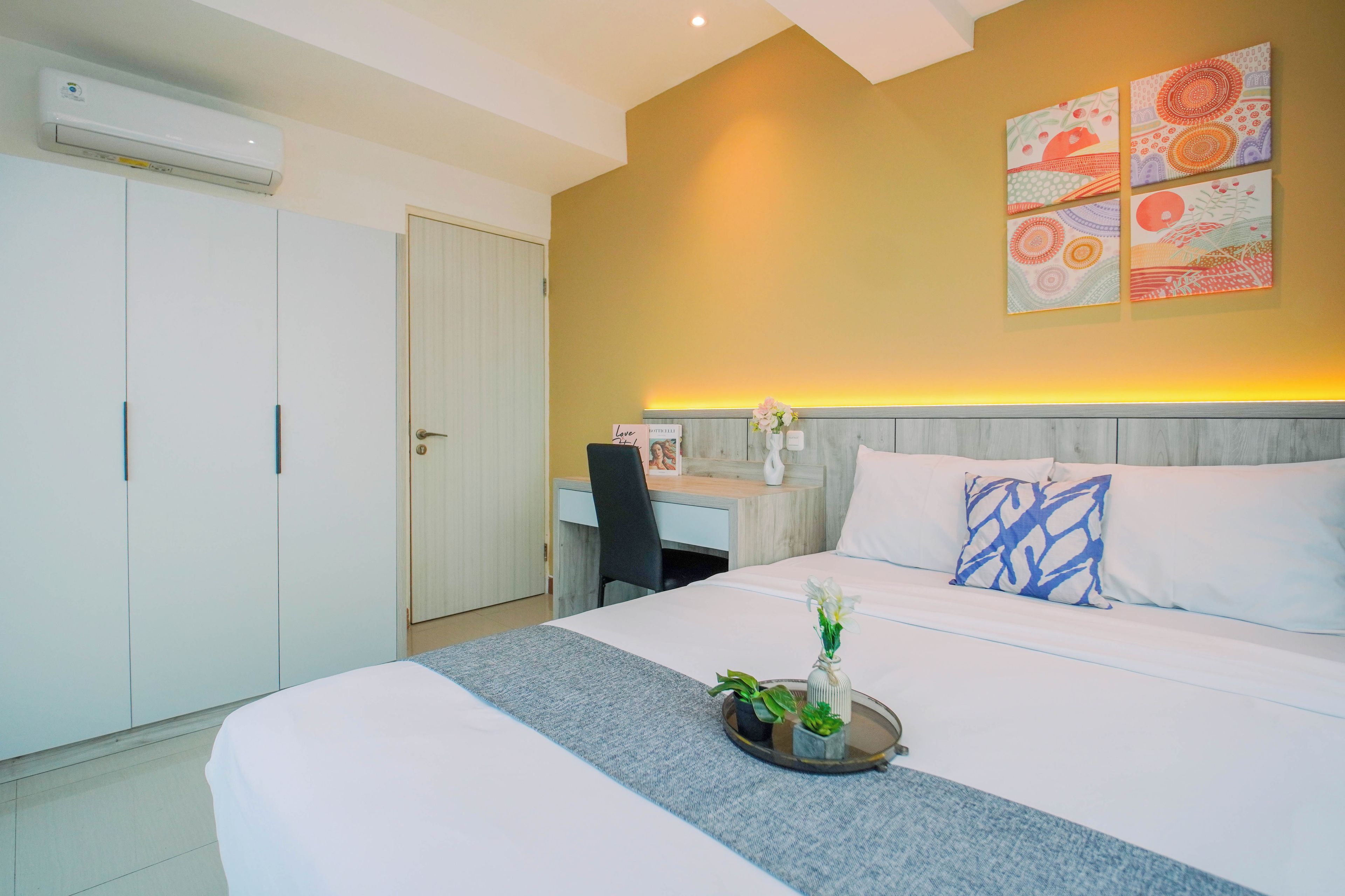 A hotel room with a bed, a desk, and a wardrobe.