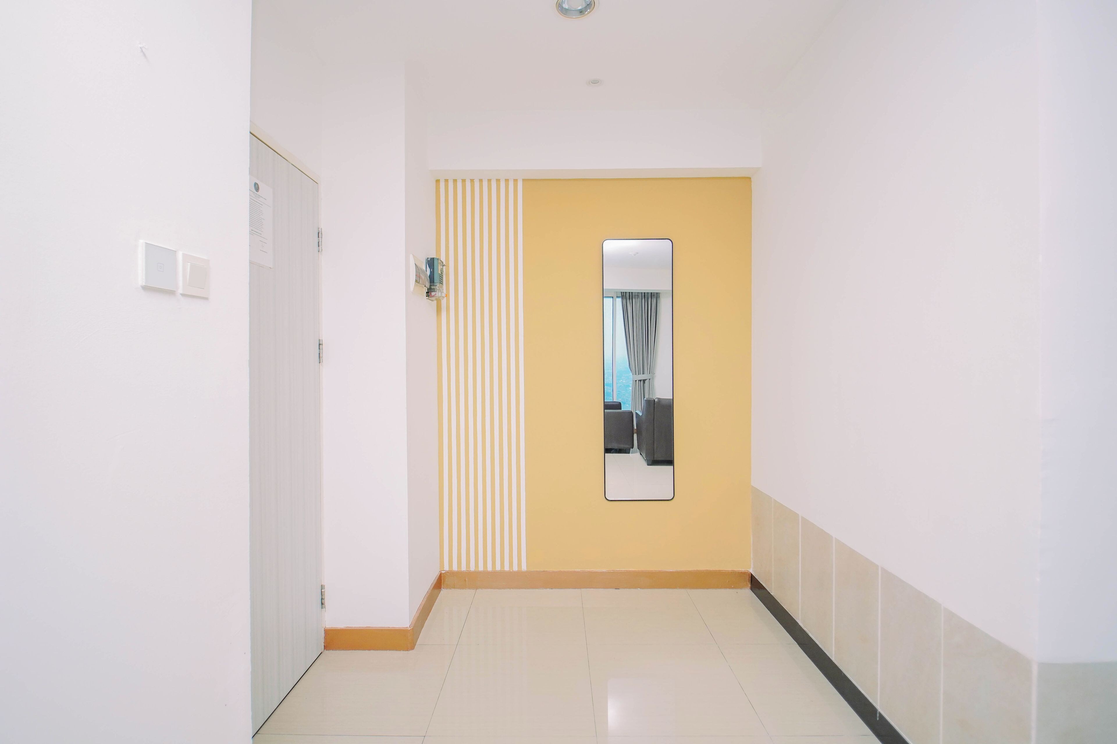 A hallway with a door, a mirror, and a striped wall.