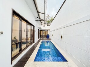 A narrow indoor swimming pool with a tiled floor and glass doors on one side. - 2Br Jwk Bali Private Pool Villa Near Pandawa Beach (Kutuh)