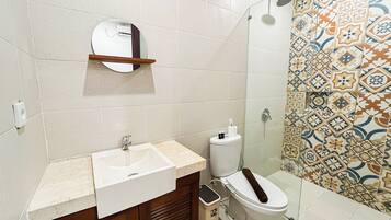 A bathroom with a sink, toilet, and shower.
