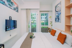 Ein Hotelzimmer mit einem Bett, einem Fernseher, einem Fenster und einer Tür.