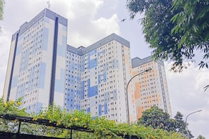 Un immeuble résidentiel à plusieurs étages, doté d’une architecture moderne, caractérisé par une façade composée d’une grille de fenêtres et de balcons.