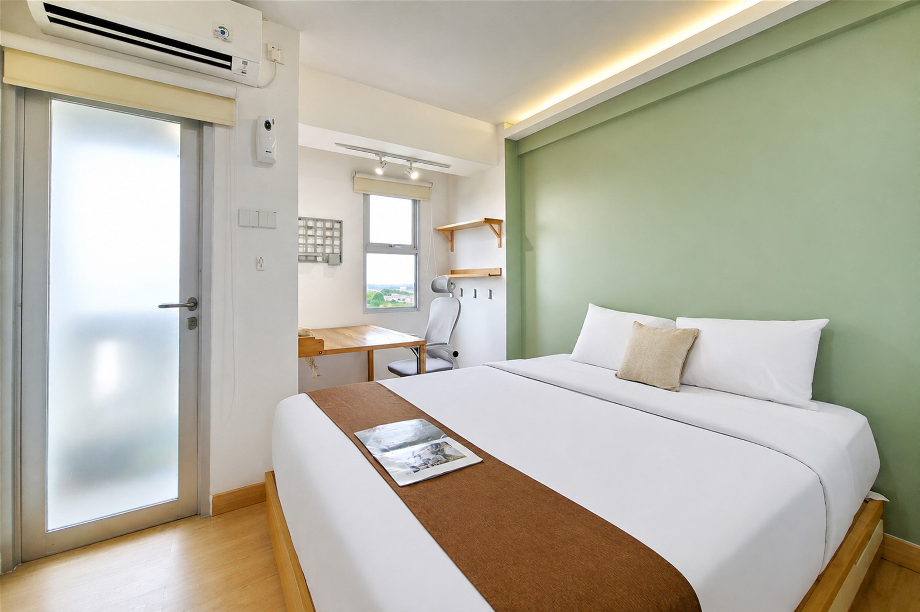 A hotel room with a bed, a desk, and a chair.