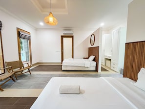 Ett hotellrum med en säng, en stol, en garderob och en hängande lampa.