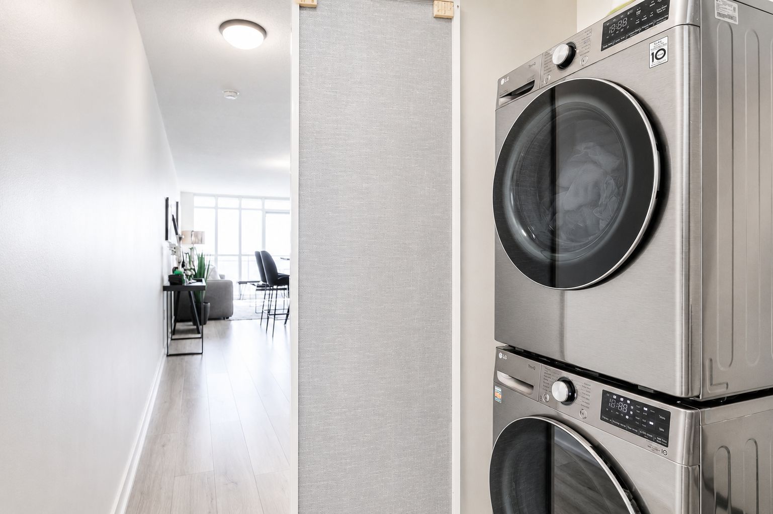 A laundry room with stacked front-loading washers and dryers.