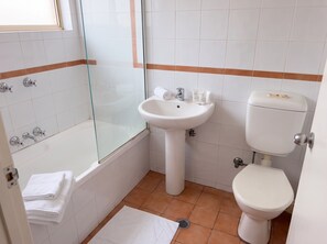 A bathroom with a bathtub, a sink, and a toilet. - Bondi 1BR Apartment, Private Balcony | 2 Min Walk to Beach, Sleeps 4 (Bondi Beach)