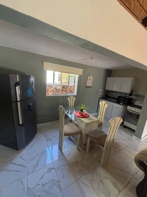 A kitchen with a dining table, chairs, a refrigerator, a window with a view, and a stove. - Luxurious 5-bedroom House With Private Pool in Cabrera (Cabrera)