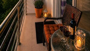Ein Balkon mit Tisch, Stühlen, einem Blumentopf und einer Klimaanlage.