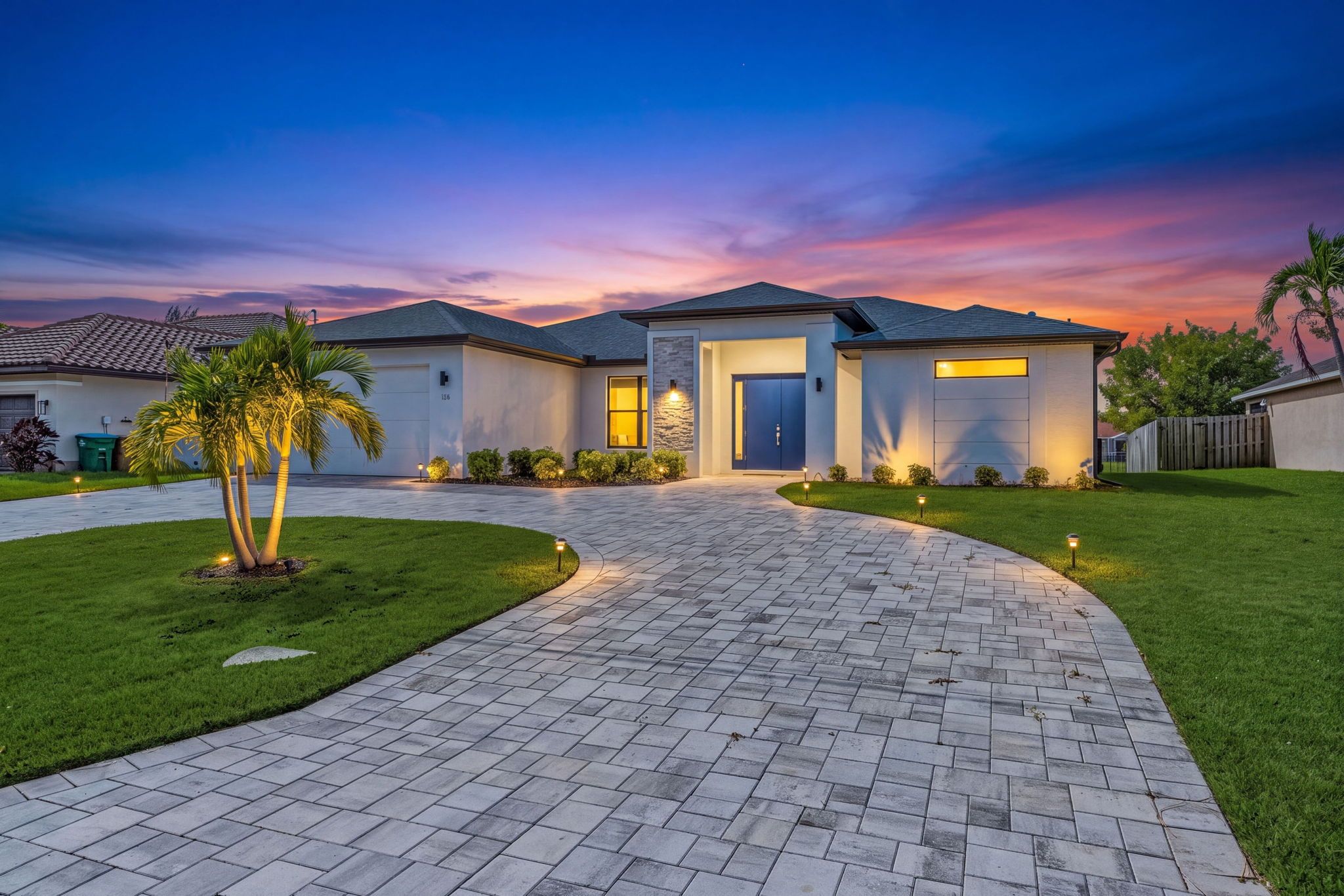 As the sun sets, landscape lighting and swaying palms give Villa Kamal a warm, welcoming glow.