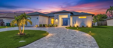 As the sun sets, landscape lighting and swaying palms give Villa Kamal a warm, welcoming glow.