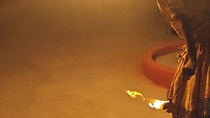 A person performing a fire act with a torch, with a blurred background. - The desert view  (Jaisalmer)