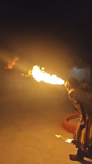 A person performing a fire act with a torch, with a blurred background. - The desert view (Jaisalmer)